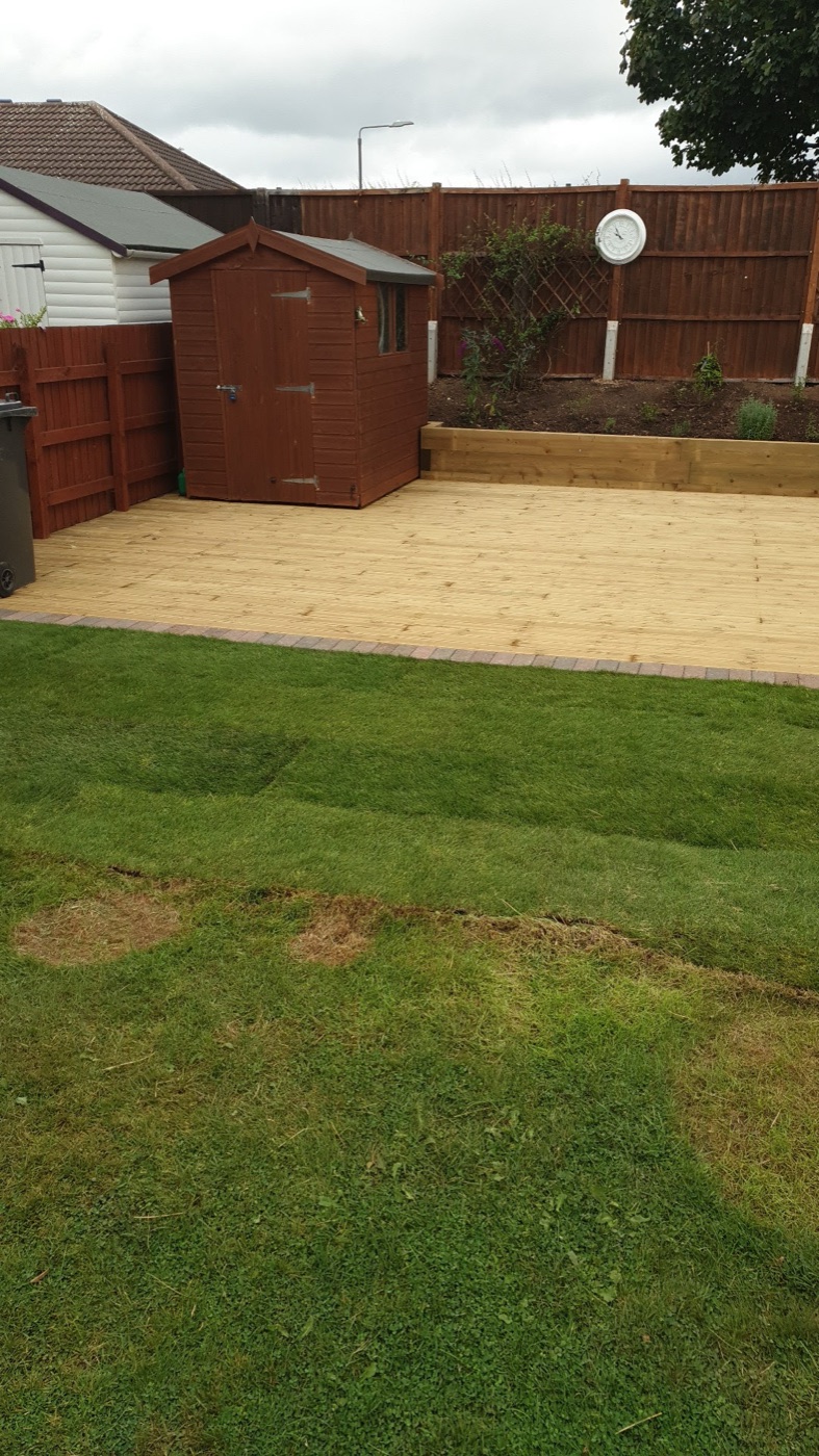 A completed garden project with a new deck, shed and freshly laid turf