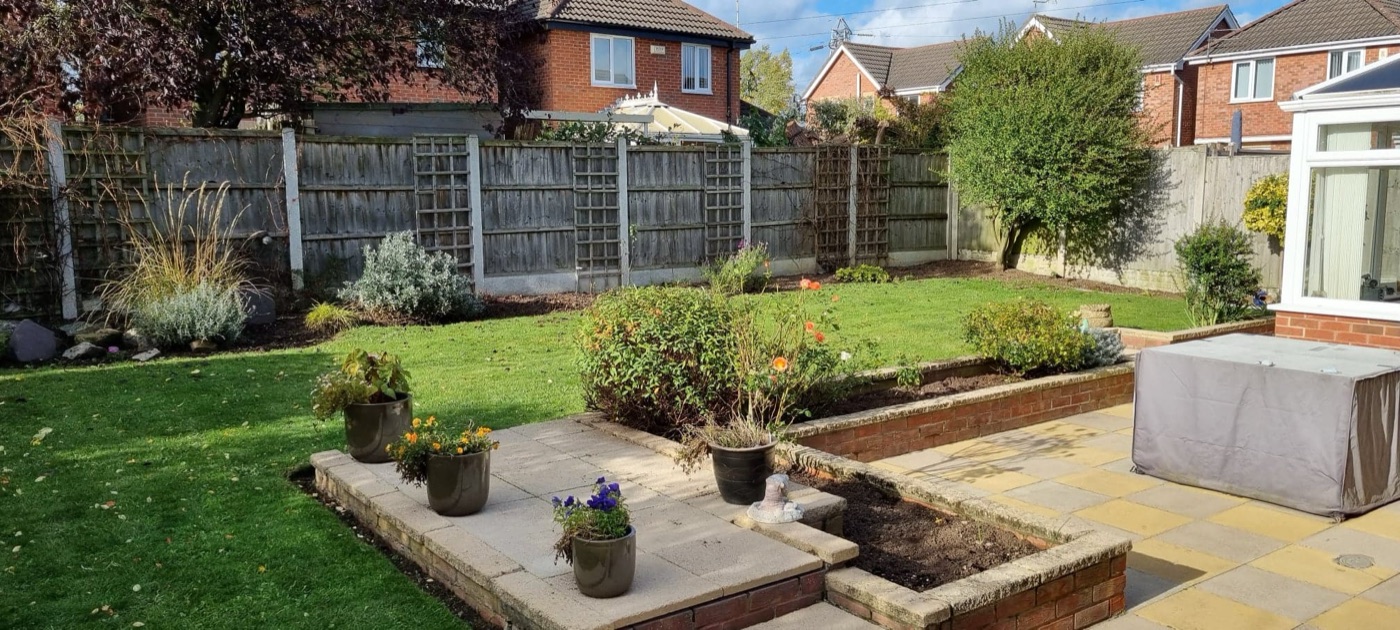 A tidy patio, raised flowerbeds and lawn after a garden tidy-up
